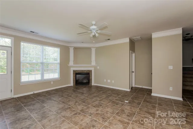 a view of an empty room with a fireplace and a window