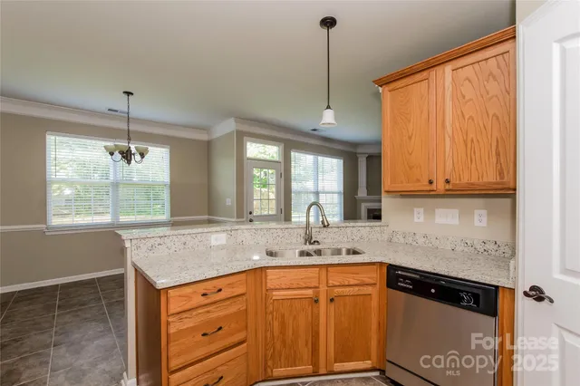 a kitchen with stainless steel appliances granite countertop a sink a window and cabinets