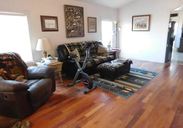 a living room with furniture and a wooden floor