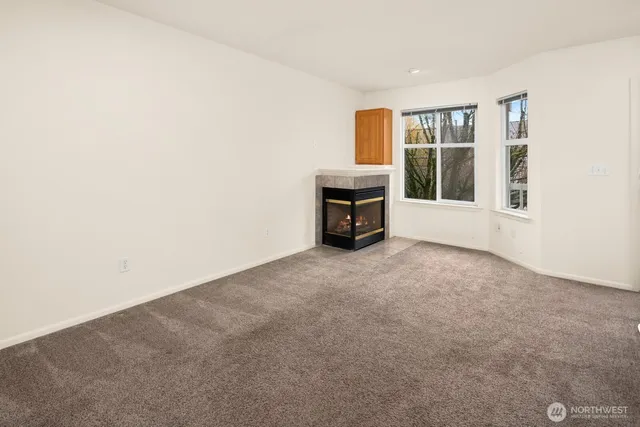 an empty room with a fireplace and a window