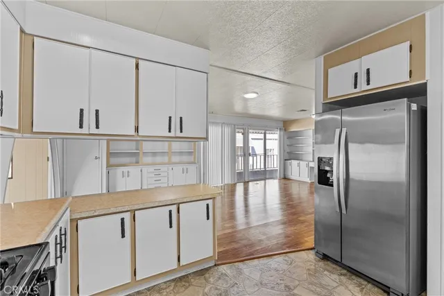a kitchen with white cabinets and window