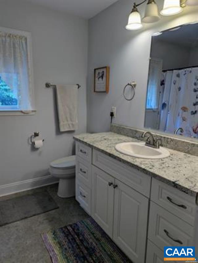 4489 Campbell Road Troy, VA 22974 - Photo 16 of 33 a bathroom with a granite countertop sink a toilet and a mirror