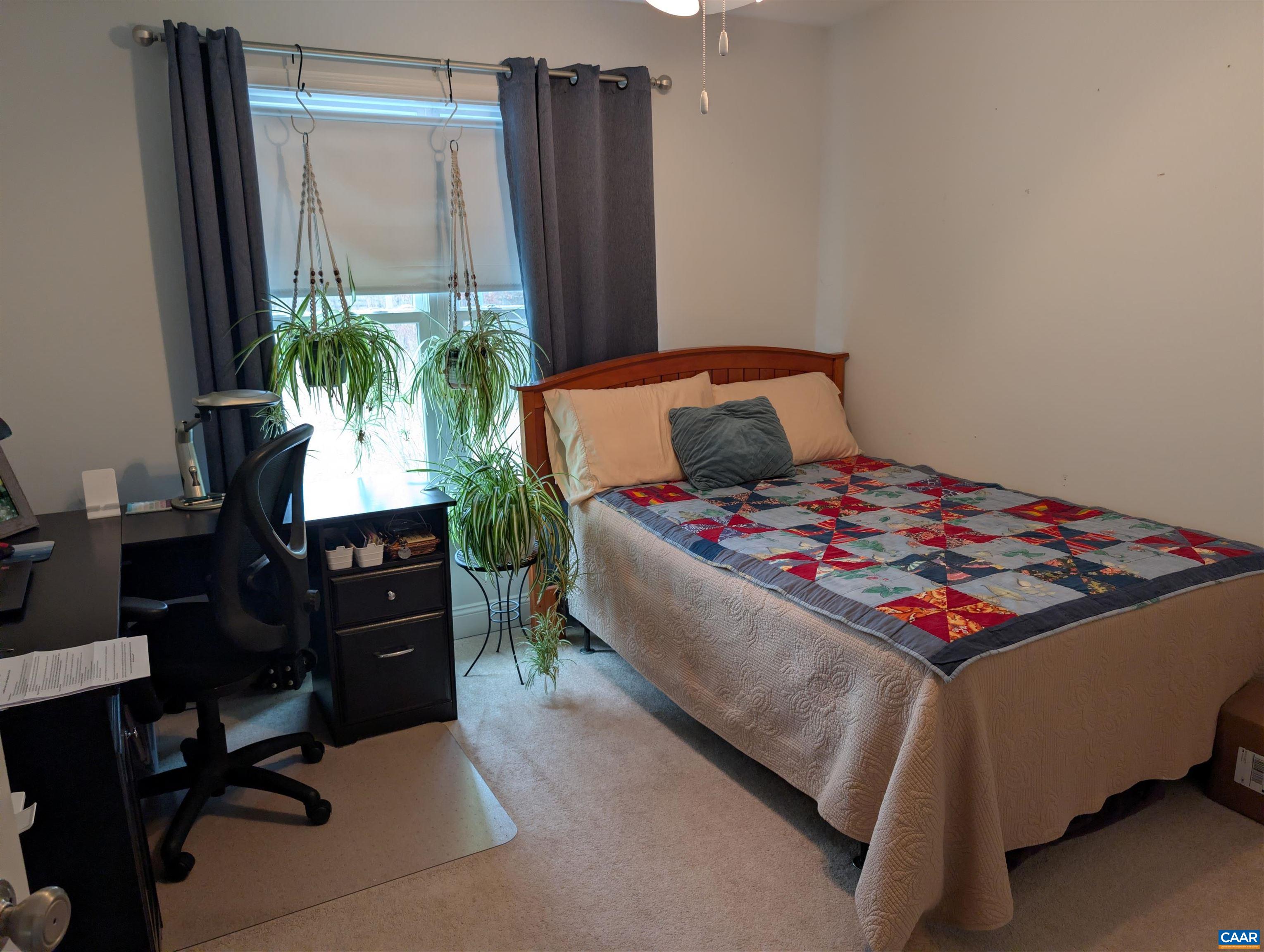 4489 Campbell Road Troy, VA 22974 - Photo 18 of 33 a bedroom with a bed table chair and a potted plant
