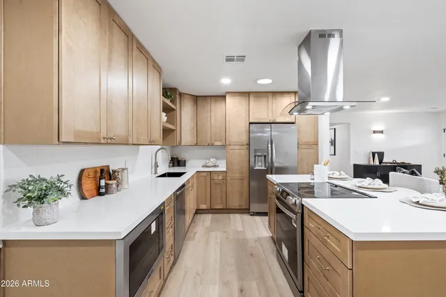 a kitchen that has a lot of cabinets and wooden floor