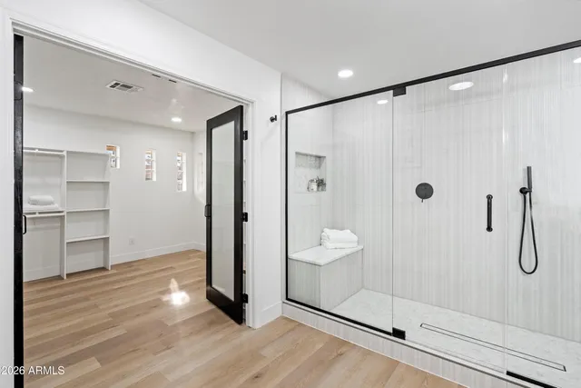 a bathroom with a glass shower door and a sink