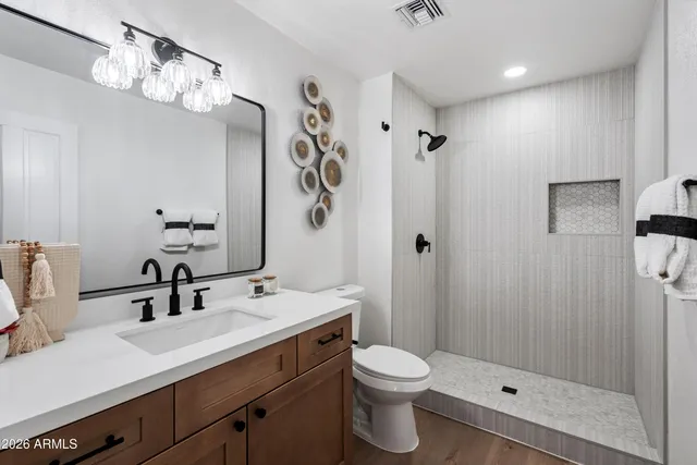 a bathroom with a double vanity sink mirror and toilet