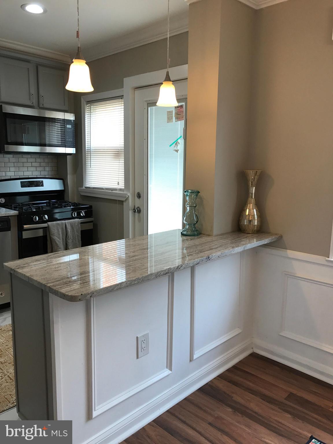 1441 Walker Avenue Baltimore, MD 21239 - Photo 2 of 28 a kitchen with stainless steel appliances a sink a microwave a refrigerator and cabinets