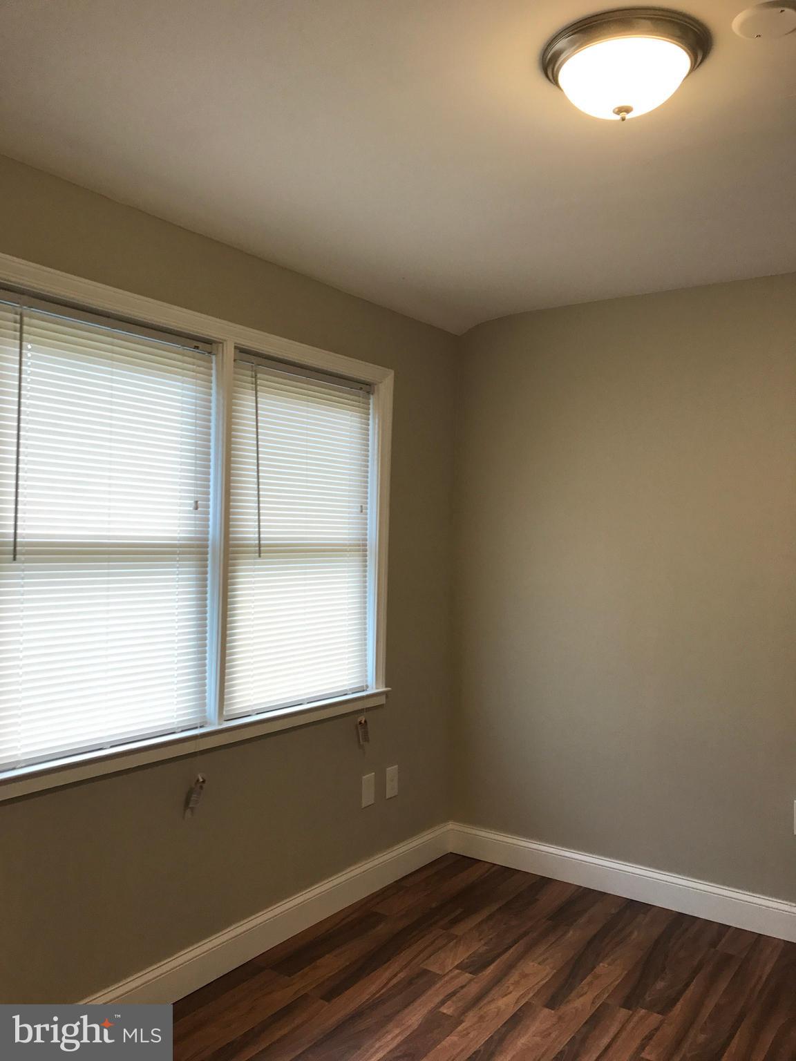 1441 Walker Avenue Baltimore, MD 21239 - Photo 26 of 28 a view of a room with wooden floor and windows