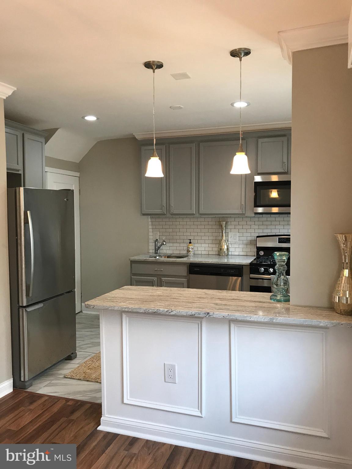 1441 Walker Avenue Baltimore, MD 21239 - Photo 5 of 28 a kitchen with stainless steel appliances granite countertop a sink a stove and a refrigerator