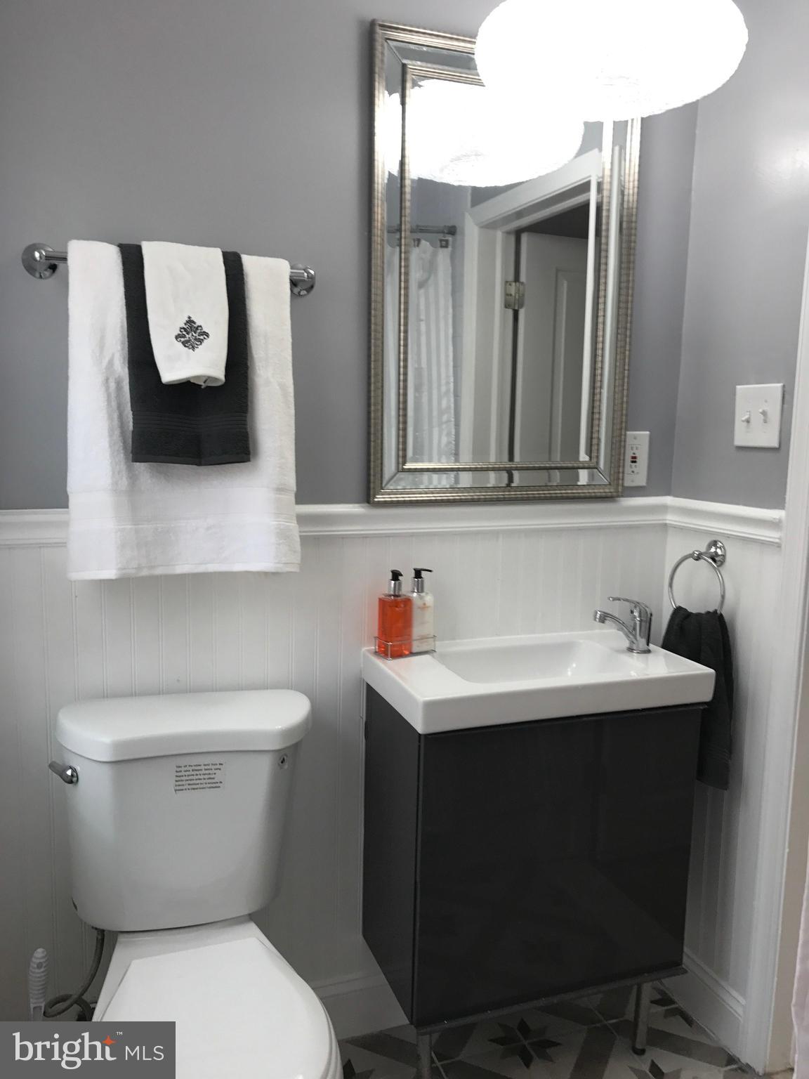 1441 Walker Avenue Baltimore, MD 21239 - Photo 8 of 28 a bathroom with a toilet sink and mirror