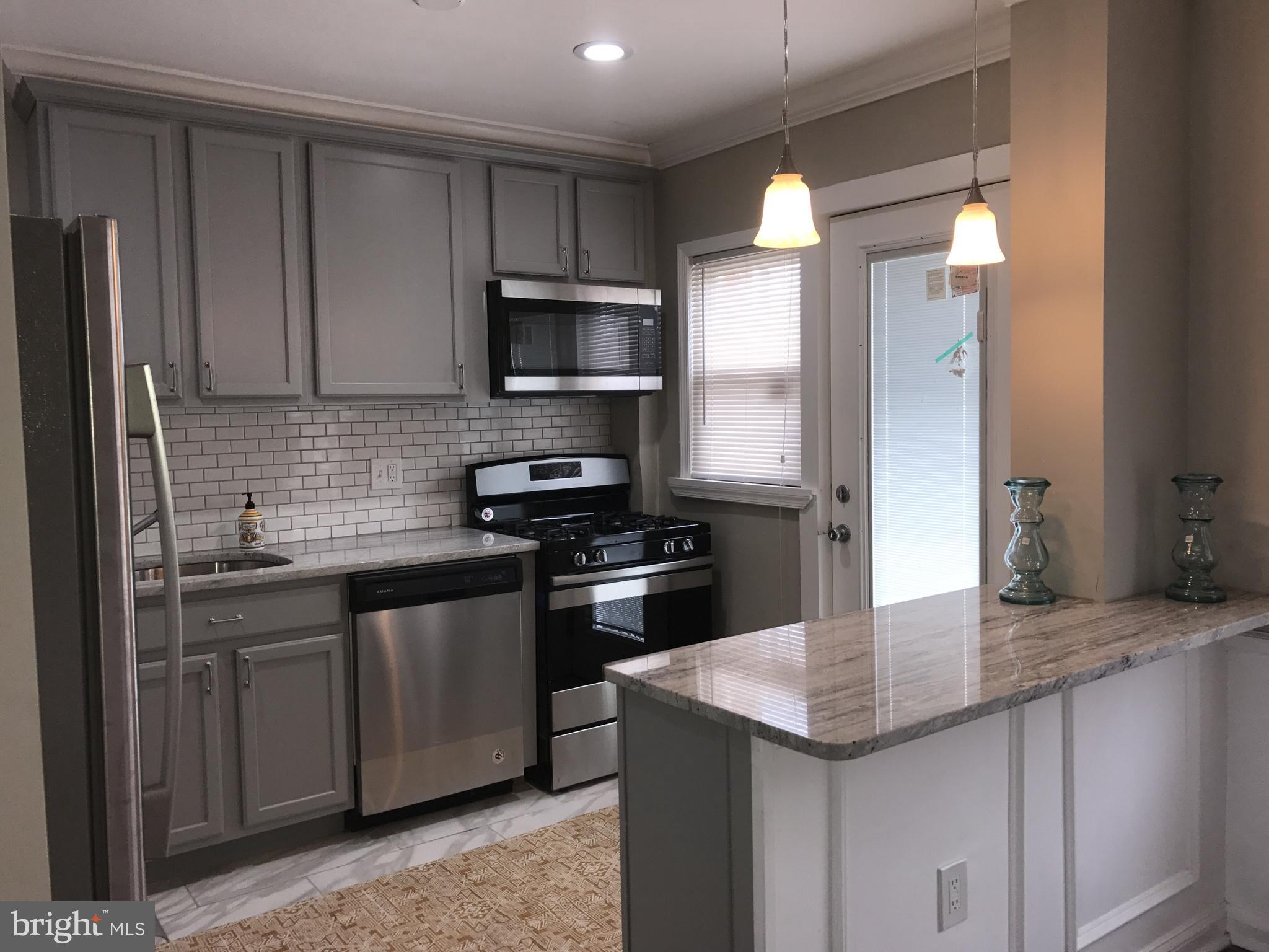 1441 Walker Avenue Baltimore, MD 21239 - Photo 10 of 28 a kitchen with stainless steel appliances granite countertop a sink a stove a refrigerator and cabinets