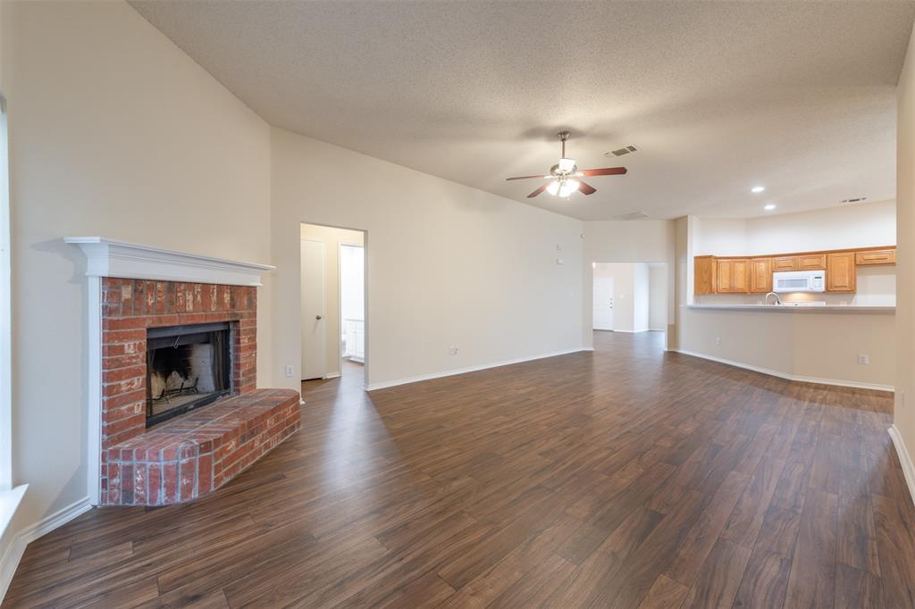 202 Whitestone Way Weatherford, TX 76085 - Photo 11 of 35 a view of an empty room with wooden floor fireplace and a window