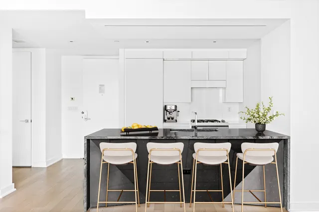 a kitchen with granite countertop a table and chairs in it