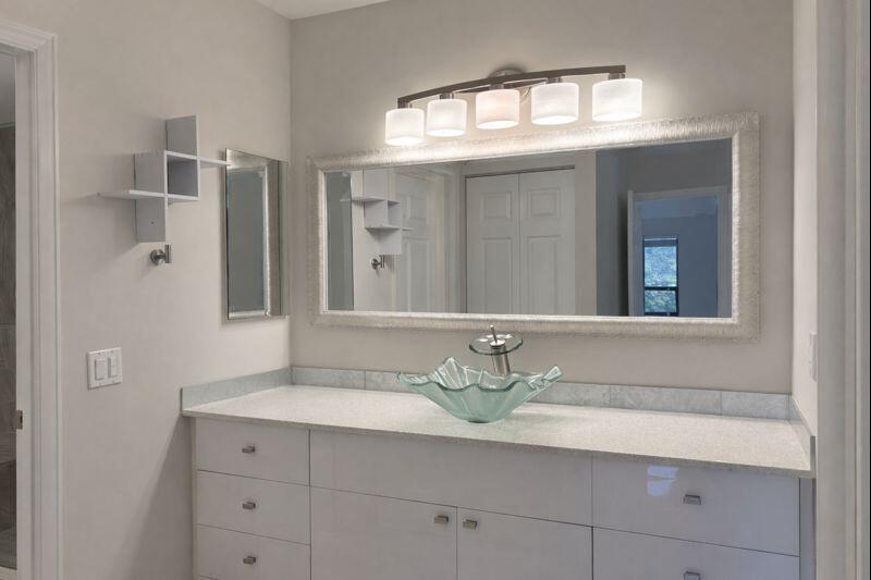 21851 Arriba Real, Unit L Boca Raton, FL 33433 - Photo 14 of 26 a bathroom with a sink a mirror and a window