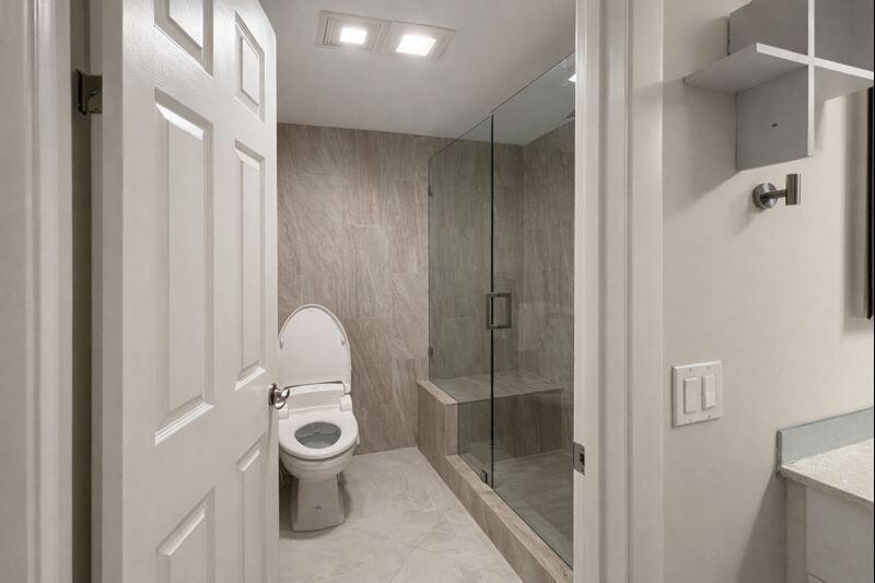 21851 Arriba Real, Unit L Boca Raton, FL 33433 - Photo 15 of 26 a bathroom with a shower and mirror