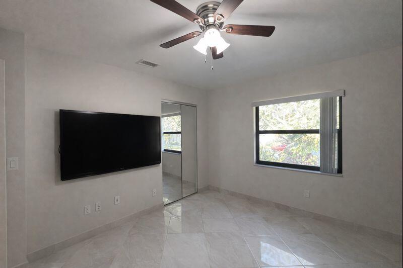 21851 Arriba Real, Unit L Boca Raton, FL 33433 - Photo 17 of 26 a view of an empty room with a window and a flat screen tv