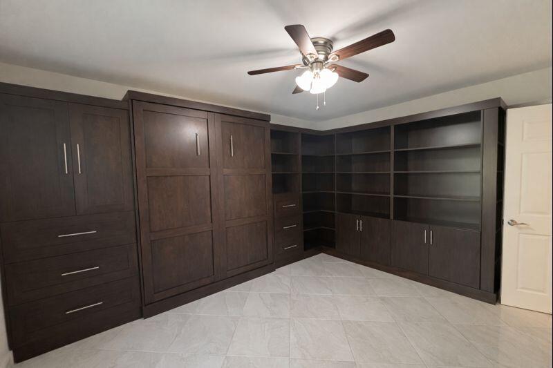 21851 Arriba Real, Unit L Boca Raton, FL 33433 - Photo 18 of 26 a large bedroom with a dresser and a chandelier fan