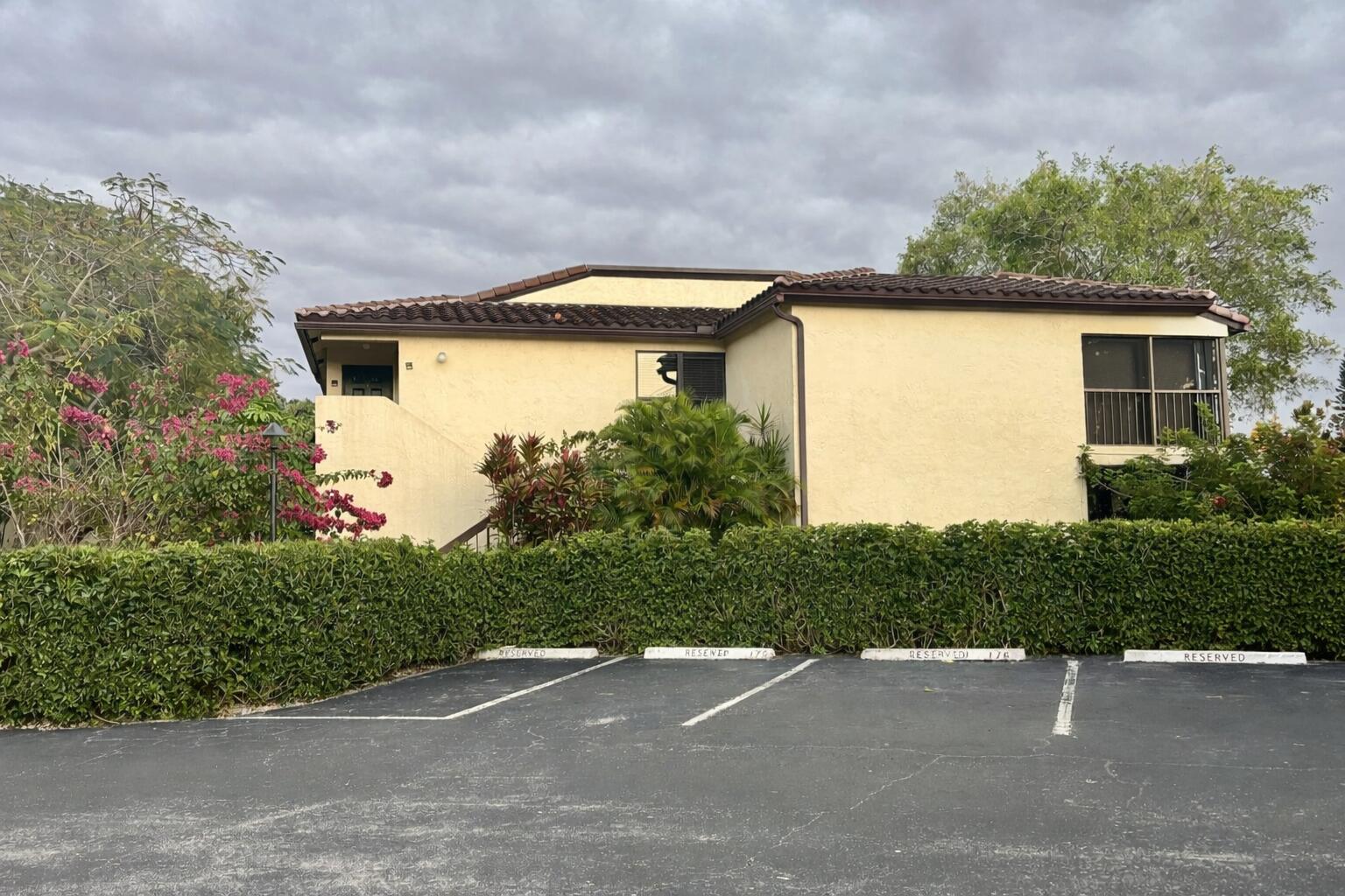 21851 Arriba Real, Unit L Boca Raton, FL 33433 - Photo 24 of 26 a front view of a house with a yard and garage
