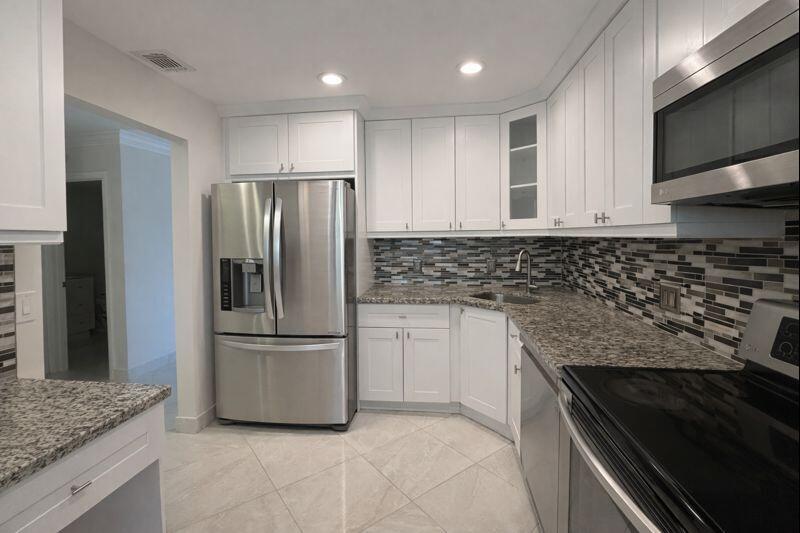 21851 Arriba Real, Unit L Boca Raton, FL 33433 - Photo 4 of 26 a kitchen with granite countertop a refrigerator and a sink