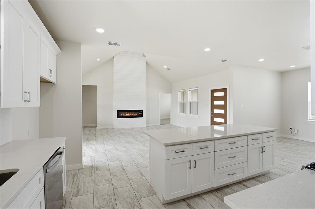 532 Highview Court Godley, TX 76044 - Photo 24 of 39 Open-concept living space featuring a vaulted ceiling and an electric fireplace with a shiplap surround