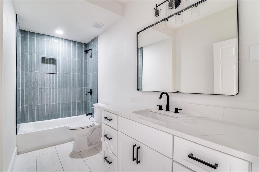 718 Grandview Avenue Dallas, TX 75223 - Photo 23 of 26 a bathroom with a granite countertop sink a toilet a mirror and shower