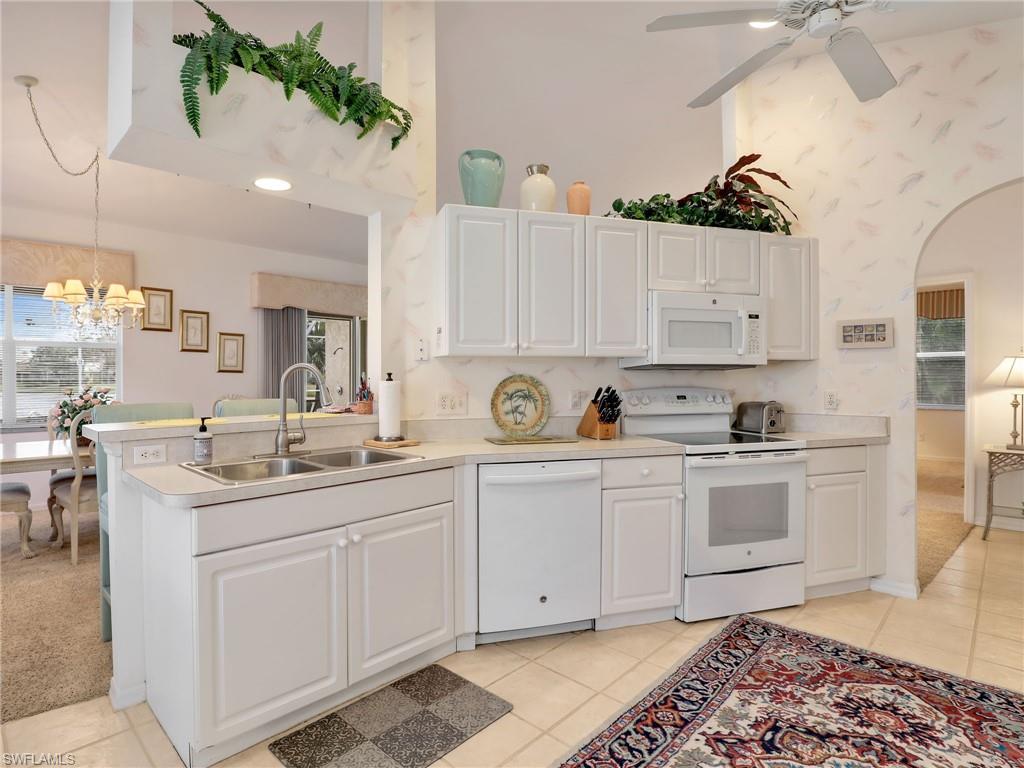 586 Crossfield Circle Naples, FL 34104 - Photo 14 of 38 a kitchen with a sink and cabinets