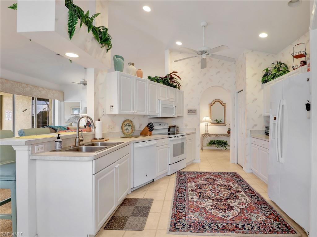 586 Crossfield Circle Naples, FL 34104 - Photo 15 of 38 a kitchen with white cabinets and sink