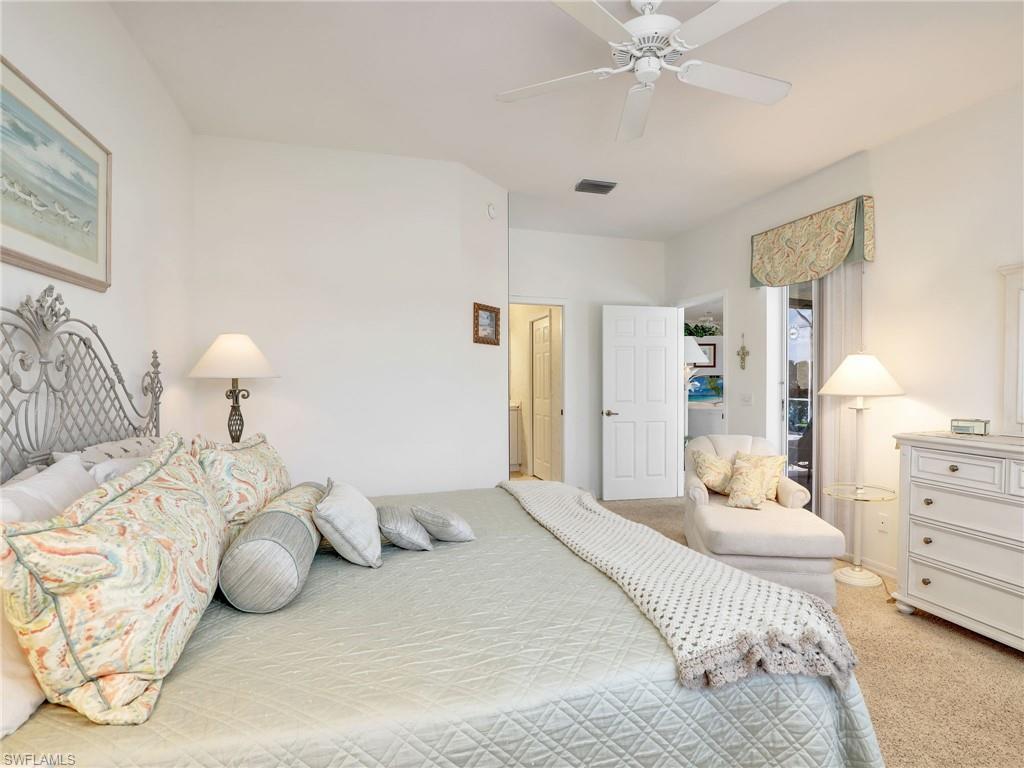 586 Crossfield Circle Naples, FL 34104 - Photo 18 of 38 a bedroom with a bed and a chandelier