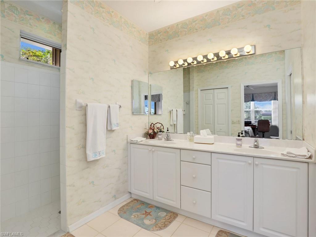 586 Crossfield Circle Naples, FL 34104 - Photo 19 of 38 a bathroom with a sink and a mirror
