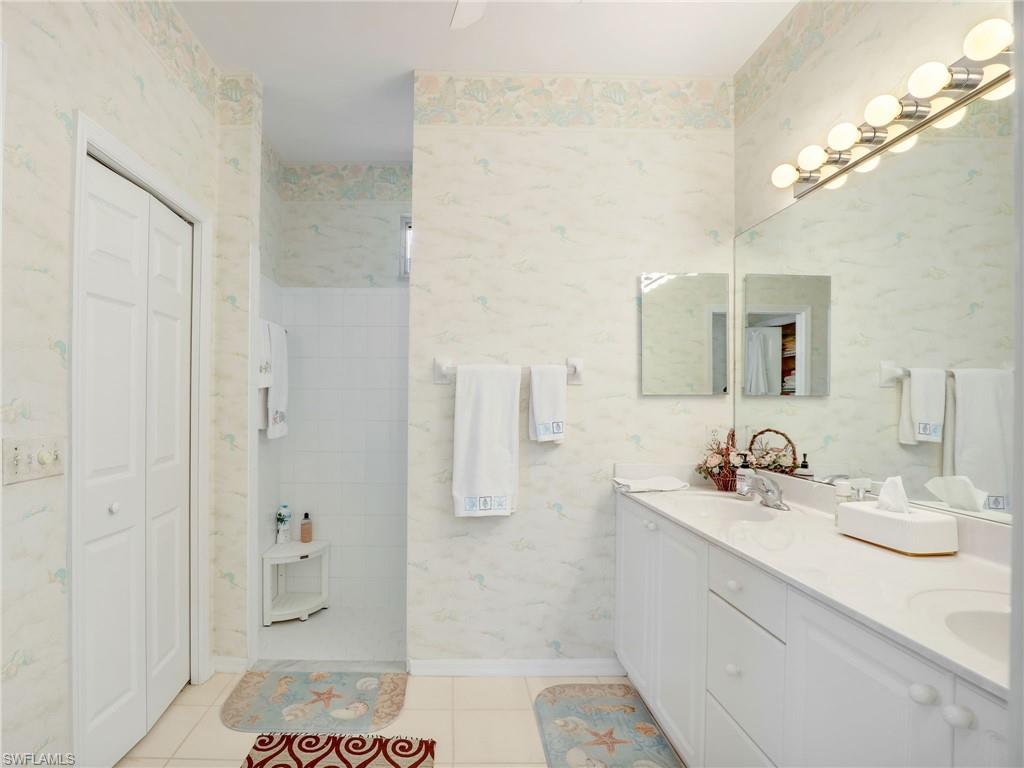 586 Crossfield Circle Naples, FL 34104 - Photo 20 of 38 a bathroom with a sink and a mirror