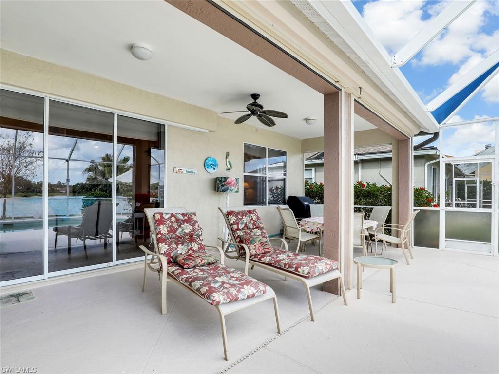 586 Crossfield Circle Naples, FL 34104 - Photo 22 of 38 a living room with furniture a floor to ceiling window and a table