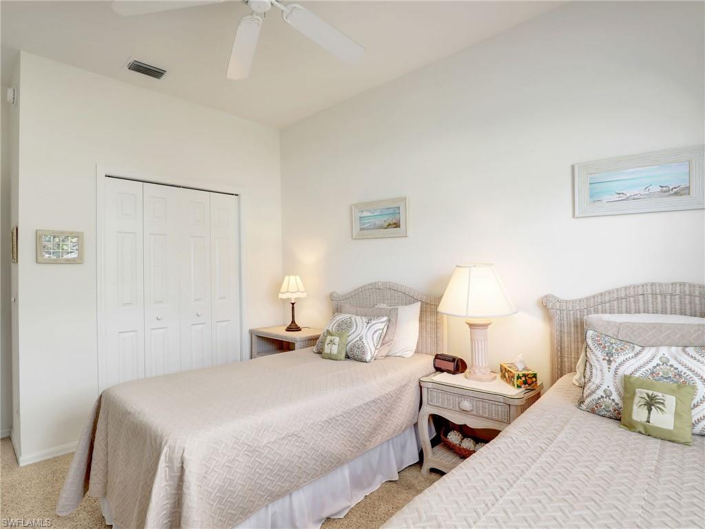 586 Crossfield Circle Naples, FL 34104 - Photo 27 of 38 a bedroom with a bed and a lamp on dresser