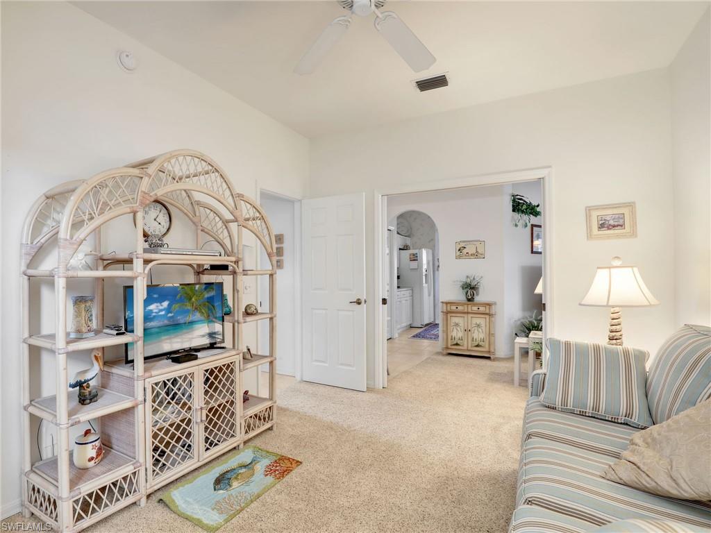 586 Crossfield Circle Naples, FL 34104 - Photo 30 of 38 a living room with furniture a flat screen tv and a lamp