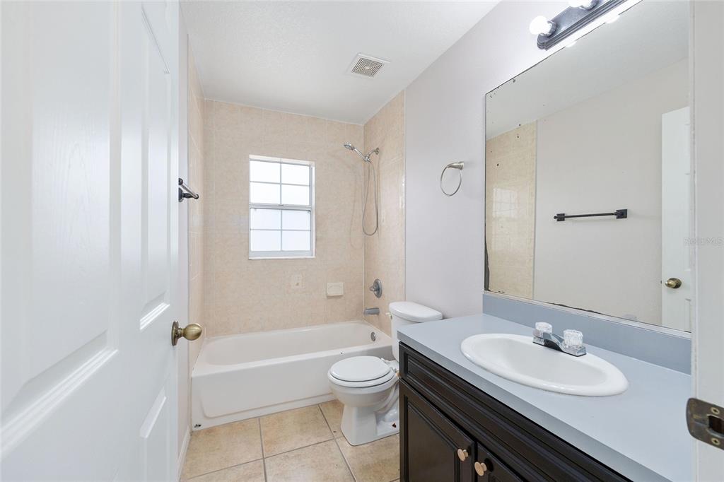 15434 Southwest 23rd Court Road Ocala, FL 34473 - Photo 32 of 41 a bathroom with a granite countertop sink toilet a mirror and bathtub
