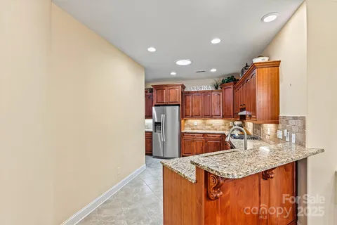 a kitchen with granite countertop kitchen island stainless steel appliances a sink and cabinets