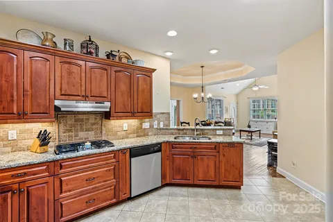 a kitchen with kitchen island granite countertop stainless steel appliances a sink a stove and cabinets