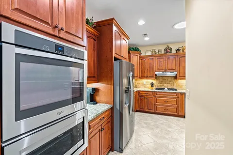 a kitchen with stainless steel appliances granite countertop a refrigerator and a stove