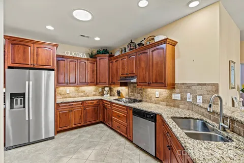 a kitchen with stainless steel appliances granite countertop a sink stove and refrigerator