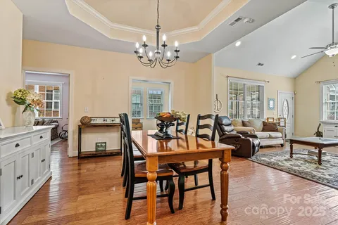 a view of a dining room with furniture a chandelier and wooden floor