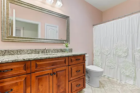 a bathroom with a granite countertop sink a toilet and a mirror