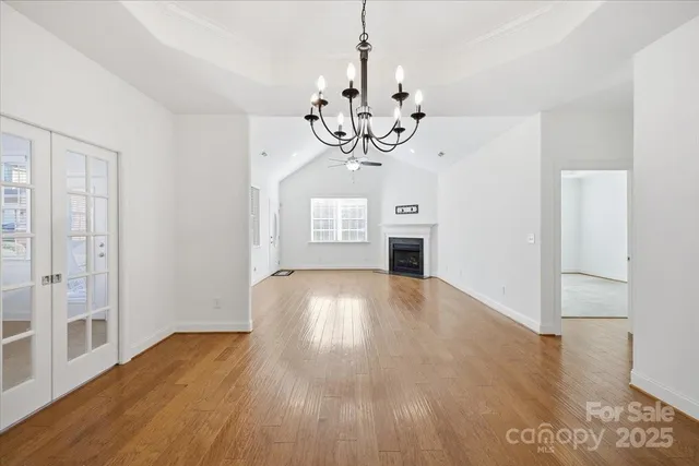 an empty room with windows and fireplace