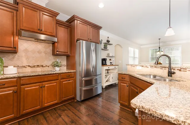 a kitchen with granite countertop a sink and stainless steel appliances