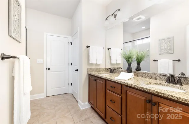 a bathroom with a granite countertop double vanity sink mirror and
