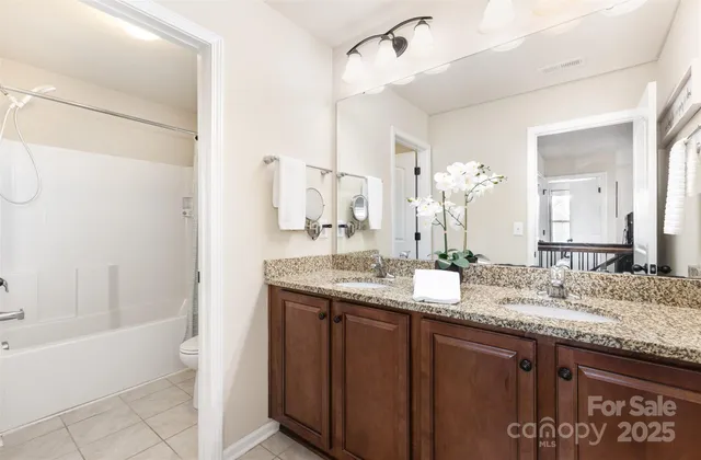 a bathroom with a granite countertop sink a mirror and a bathtub