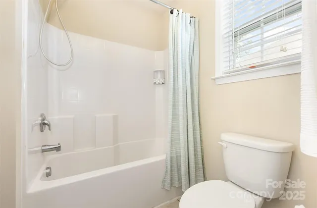 a white toilet sitting next to a bath tub shower