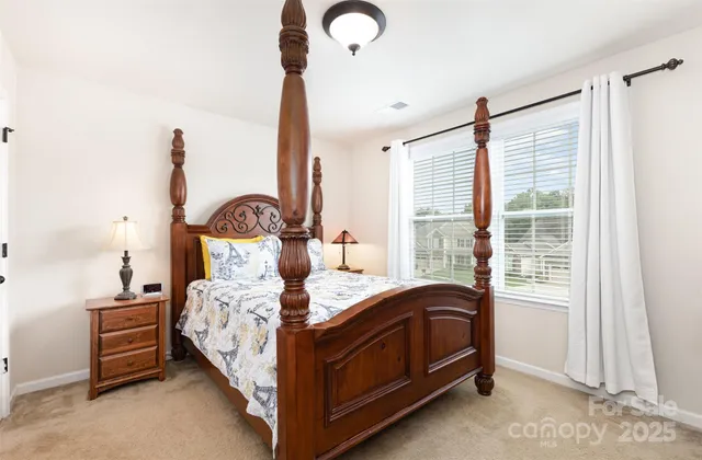 a bed sitting in a bedroom next to a window