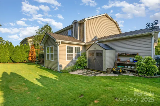 a view of a house with a big yard and large trees