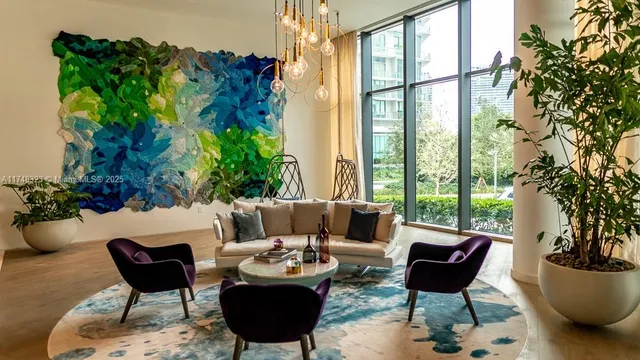 a living room with furniture kitchen view and large windows