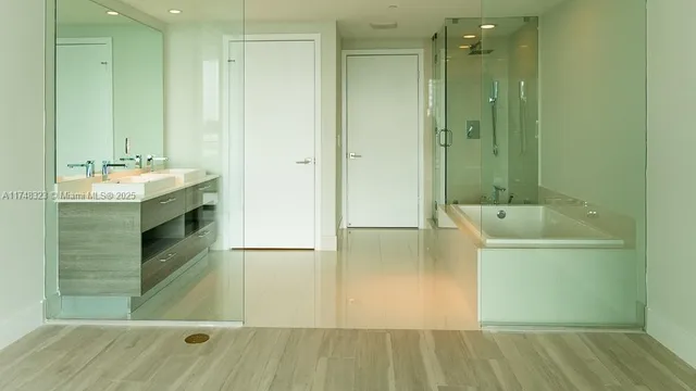 an empty room with wooden floor and a bathroom