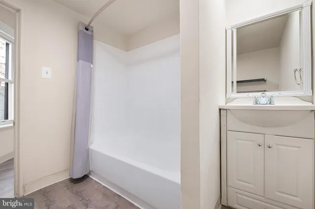 a bathroom with a bathtub a sink a vanity and a mirror